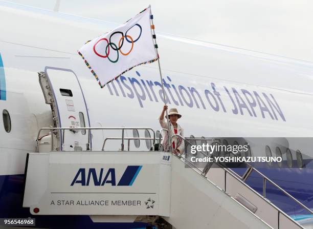 Tokyo Governor Yuriko Koike waves the Olympic flag upon her arrival at the Haneda airport in Tokyo on August 24, 2016. Koike and Japan's Olympic...