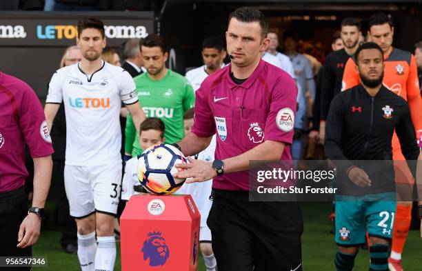 Referee Michael Oliver collects the match ball before the Premier League match between Swansea City and Southampton at Liberty Stadium on May 8, 2018...