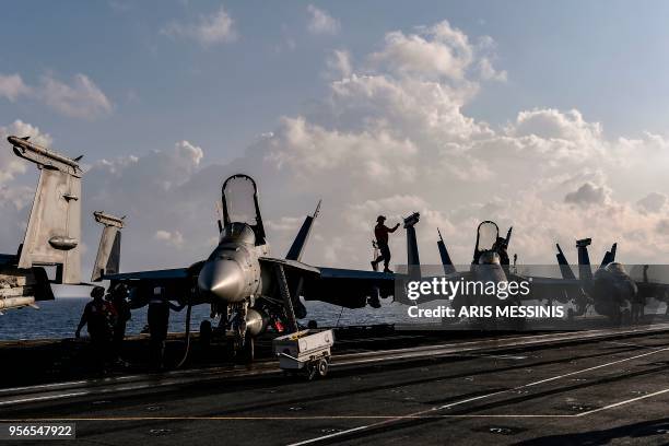 Crew member checks a missile on an F18 Hornet fighter jet stationed on the deck of the US navy aircraft carrier USS Harry S. Truman in the eastern...