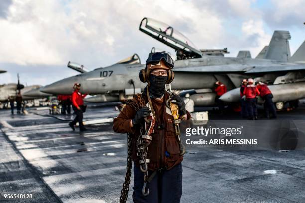 Crew members of US aircraft carrier USS Harry S Truman work on the flight deck of the ship in the eastern Mediterranean Sea on May 8, 2018. - The...