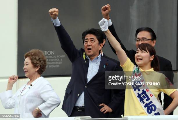 Japanese Prime Minister and ruling Liberal Democratic Party leader Shinzo Abe raises his fist with his party candidate Aya Nakamura as he delivered a...