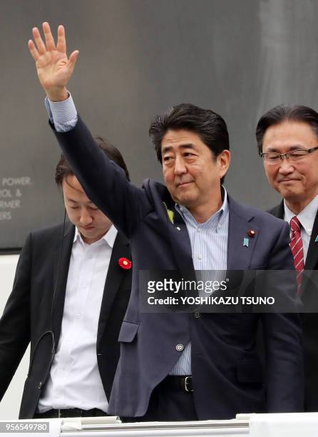 Japanese Prime Minister and ruling Liberal Democratic Party leader Shinzo Abe raises his hand to react to audience as he delivers a campaign speech...