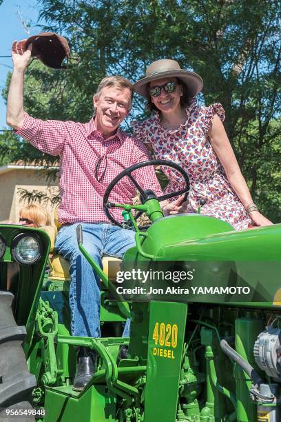 Le gouverneur démocrate du Colorado John Hickenlooper avec sa femme Robin Pringle défilent sur un tracteur lors de la fête nationale le 4 juillet...