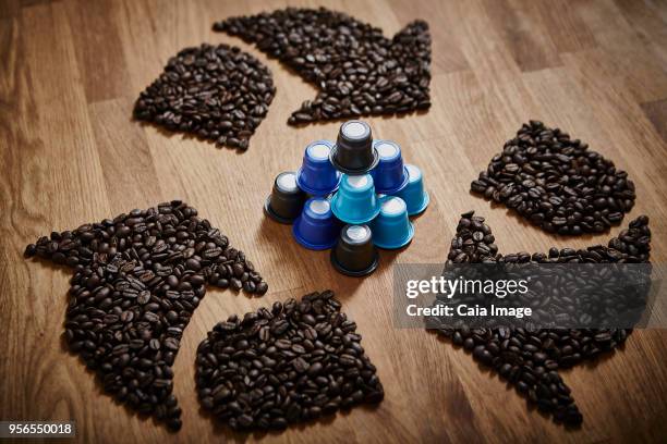 coffee beans forming recycle symbol around plastic coffee pods - coffee capsules stock-fotos und bilder