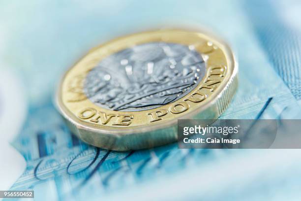 close up one pound coin on five pound note - nota de cinco pounds - fotografias e filmes do acervo
