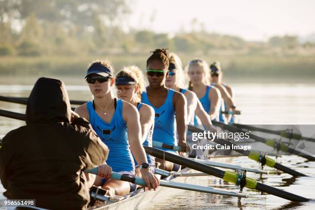 female rowing team rowing scull on lake - coxswain stock pictures, royalty-free photos & images