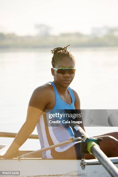 portrait confident female rower in scull on lake - sculling crew stock pictures, royalty-free photos & images