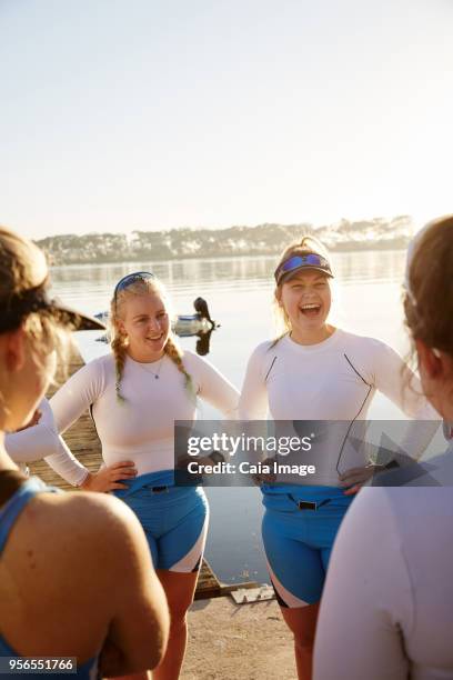 female rowing team laughing and talking at sunny lakeside - sculling crew stock pictures, royalty-free photos & images