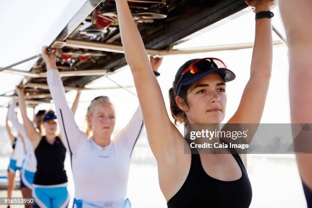 confident, determined female rowing team lifting scull overhead - sculling crew stock pictures, royalty-free photos & images