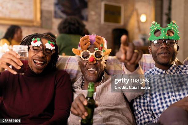 portrait playful grandfather and grandsons wearing christmas costume goggles - beer goggles stock pictures, royalty-free photos & images