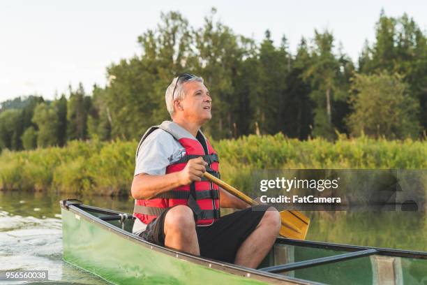late afternoon solo canoe trip - seniors canoeing stock pictures, royalty-free photos & images