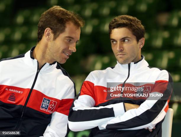 French team Richard Gasquet smiles with Gilles Simon as they attend a drawing event of the Davis Cup World Group first round tennis matches between...