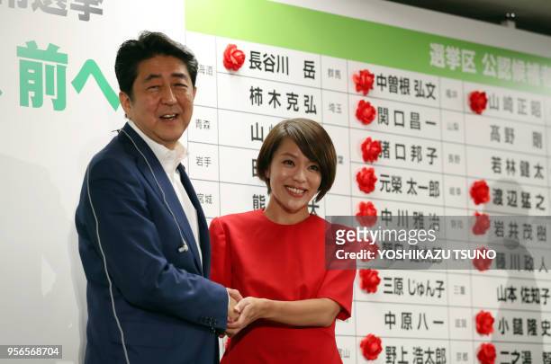 Japanese Prime Minister and ruling Liberal Democratic Party president Shinzo Abe shakes hands with hiands with his party's candidate Eriko Imai as...