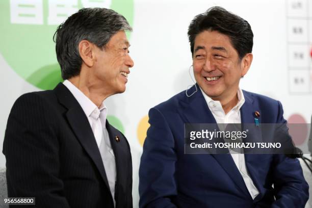 Japanese Prime Minister and ruling Liberal Democratic Party president Shinzo Abe smiles with vice president Masahiko Komura at the LDP headquarters...