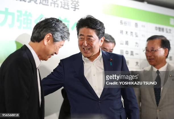 Japanese Prime Minister and ruling Liberal Democratic Party president Shinzo Abe shares smiles with party's vice president Masahiko Komura for the...