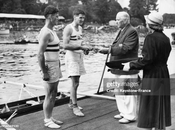 Les frères britanniques Burnell recevant leur médaille d'or pour l'épreuve d'aviron de couple, à Henley-on-Thames, Royaume-Uni le 9 août 1948.