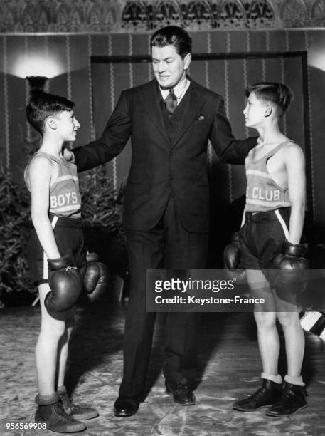 Ancien boxeur Gene Tunney encourage deux jeunes garçons, Max Savitsky et John Kuzyk, avant leur match de boxe à New York City, NY.