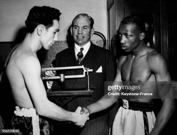 Le boxeur américain Willie Pep et le boxeur noir américain Sandy Saddler se serrent la main le 11 février 1949 à New York City, NY.