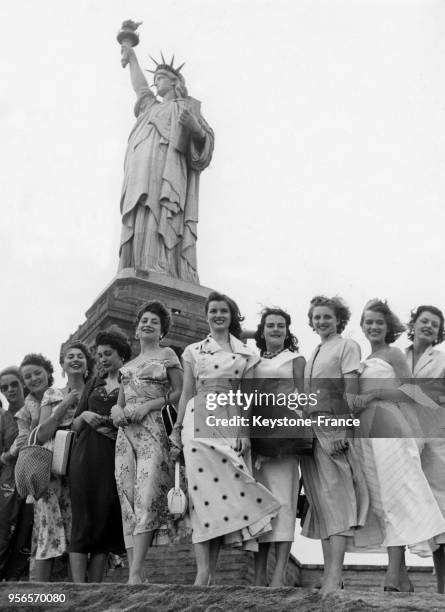 Les concurrentes à l'élection de Miss Univers 1953, dont la française Christiane Martel, posent devant la statue de la Liberté à New York aux...