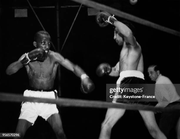 Le boxeur noir américain Sandy Saddler contre le boxeur américain Willie Pep disputant le titre de champion du monde des poids-plumes sur le ring le...