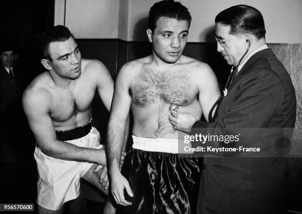 Le boxeur français Robert Villemain surveille l'examen médical par le médecin du boxeur américain Jack La Motta avant une rencontre importante entre...
