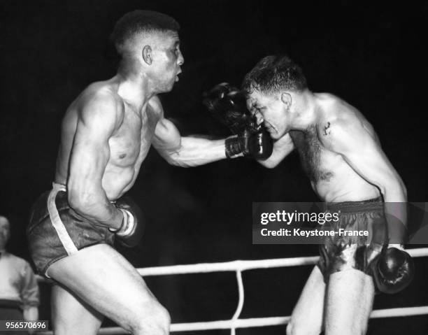 Pendant un combat de boxe, Randy Turpin donne un uppercut dans le nez de Charles Humez, à White City, Londres, Royaume-Uni le 9 juin 1953.