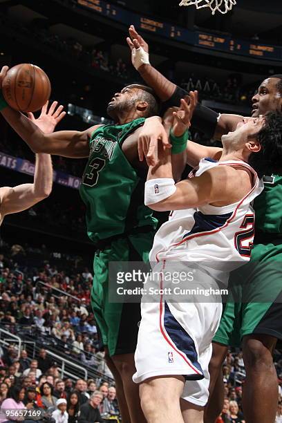 Shelden Williams of the Boston Celtics grabs a rebound against Zaza Pachulia of the Atlanta Hawks on January 8, 2010 at Philips Arena in Atlanta,...