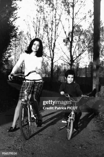Portrait de la comédienne Marie-José Nat chez elle à vélo avec son fils le 3 novembre 1969 en France.