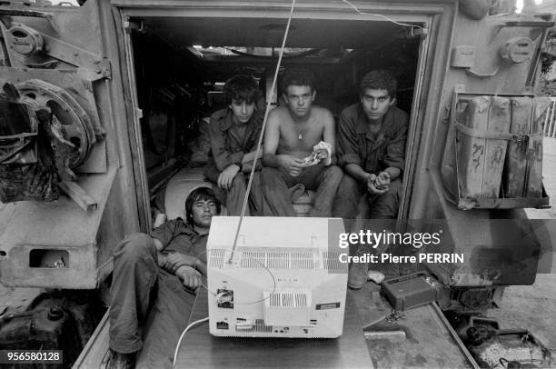Des soldats israéliens regardent la télévision assis à l'arrière d'un blindé à Beyrouth lors du conflit israélo-palestinien en aout 1982, Liban.