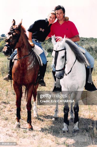 Le joueur de tennis Henri Leconte et sa femme Marie Sara à cheval en vacances au bord de la mer en juillet 1997 aux Saintes-Maries de la Mer, France.