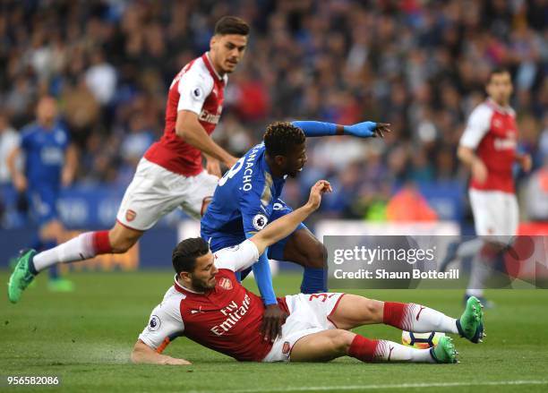 Sead Kolasinac of Arsenal collides with Kelechi Iheanacho of Leicester City and Konstantinos Mavropanos of Arsenal looks on during the Premier League...