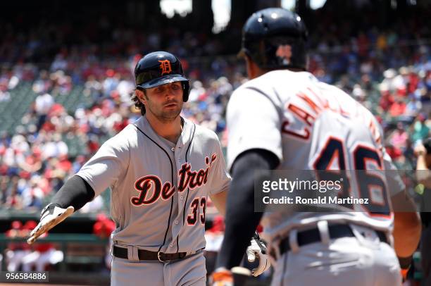 Pete Kozma of the Detroit Tigers celebrates a homerun with Jeimer Candelario of the Detroit Tigers in the third inning at Globe Life Park in...