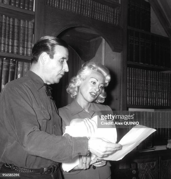Le réalisateur Christian-Jaque et sa femme Martine Carol travaillant sur un scénario, circa 1950.