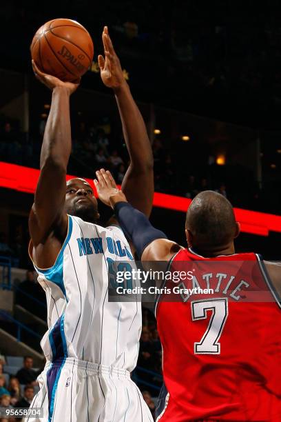 Emeka Okafor of the New Orleans Hornets shoots the ball over Tony Battie of the New Jersey Nets at the New Orleans Arena on January 8, 2010 in New...