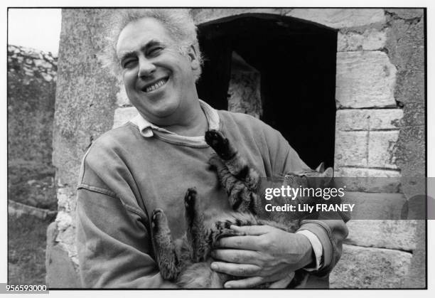 Portrait du photographe Hans Silvester dans sa maison avec son chat à Gordes, France, en 1991.