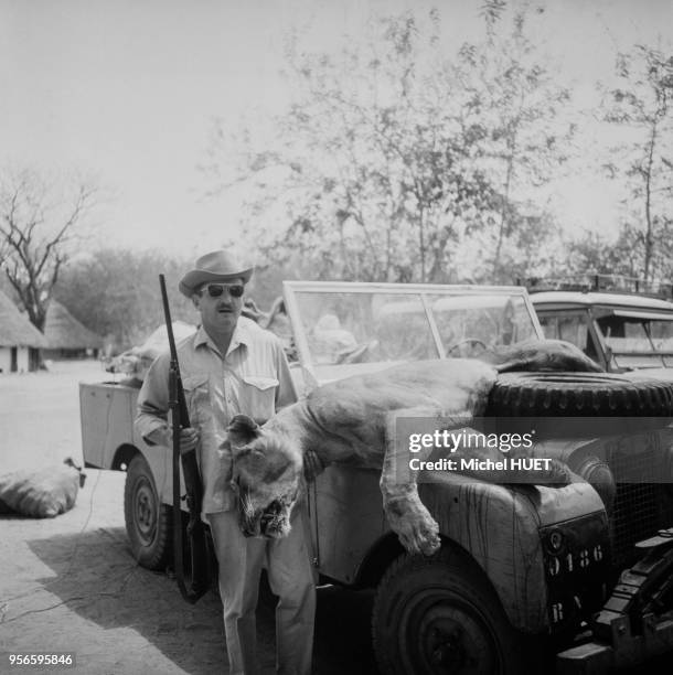 Touriste posant avec une lionne tuée lors d'un safari de chasse au Niger, circa 1950.