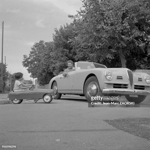 Acteur Jean-Pierre Aumont et sa fille Tina font une course de voitures a Suresnes en France, circa 1951 - L'acteur conduit une Alfa Romeo Spider 6C...