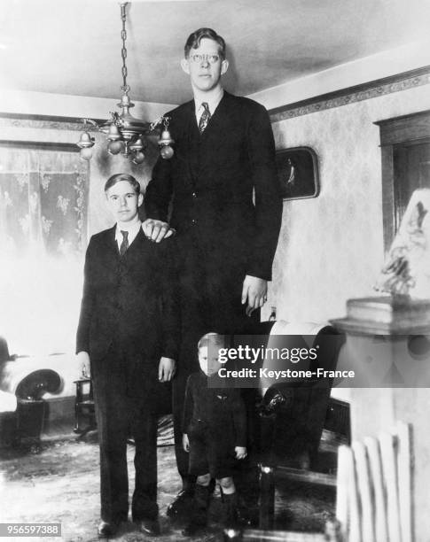Portrait du géant américain Robert Pershing Wadlow en compagnie de ses frères à Alton, Illinois, aux Etats-Unis, le 7 mars 1936.