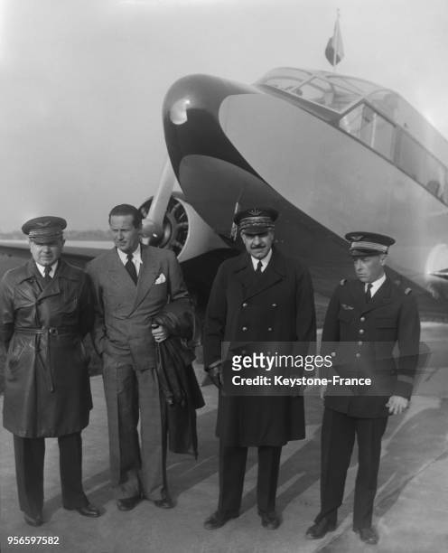 Avant le départ, devant l'avion, de gauche à droite, Messieurs Rossi, Mermoz, le ministre de l'Air le général Denain et le capitaine Girardot, à...