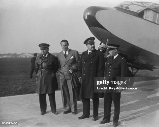 Avant le départ, devant l'avion, de gauche à droite, Messieurs Rossi, Mermoz, le ministre de l'Air le général Denain et le capitaine Girardot, à...