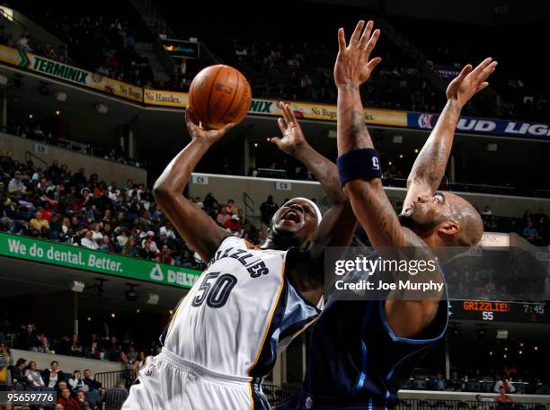 Zach Randolph of the Memphis Grizzlies shoots around Carlos Boozer of the Utah Jazz on January 8, 2010 at FedExForum in Memphis, Tennessee. NOTE TO...
