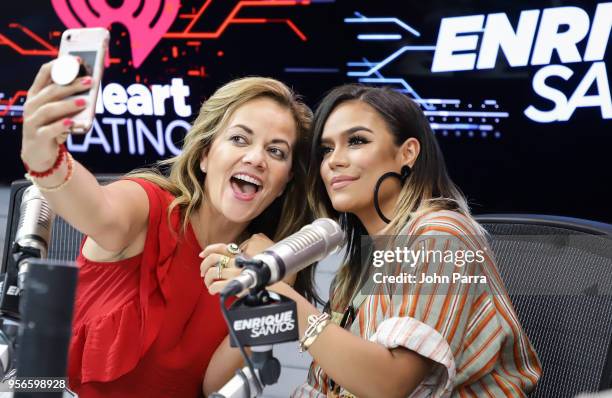 Gina Ulmos and Karol G attend The Enrique Santos Show At I Heart Latino Studios on May 9, 2018 in Miramar, Florida.