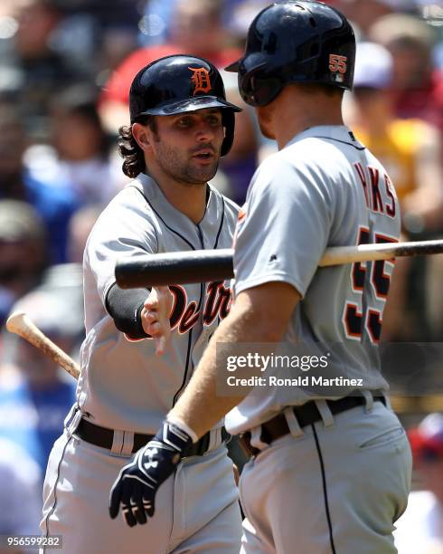 Pete Kozma of the Detroit Tigers celebrates after scoring a run with John Hicks in the fifth inning against the Texas Rangers at Globe Life Park in...