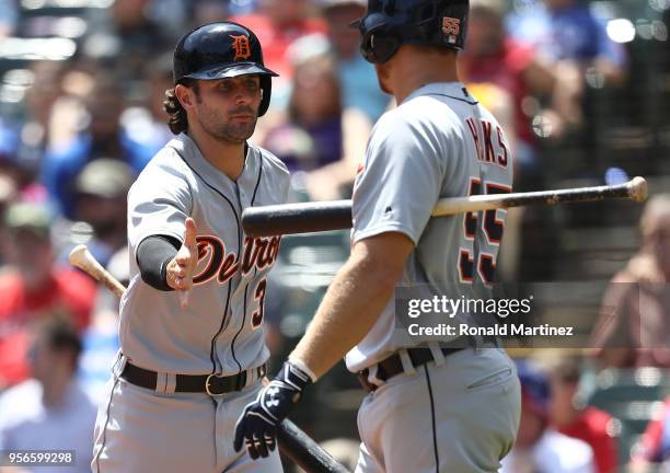 Pete Kozma of the Detroit Tigers celebrates after scoring a run with John Hicks in the fifth inning against the Texas Rangers at Globe Life Park in...