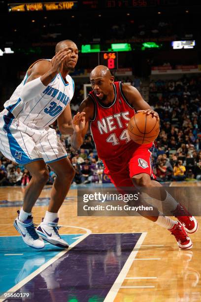 Trenton Hassell of the New Jersey Nets drives the ball around David West of the New Orleans Hornets at the New Orleans Arena on January 8, 2010 in...