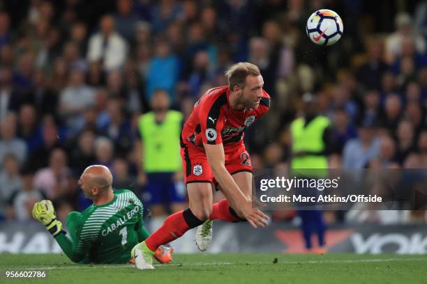 Laurent Depoitre of Huddersfield Town scores the opening goal after colliding with Chelsea goalkeeper Willy Caballero during the Premier League match...