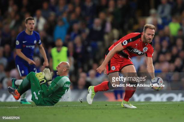 Laurent Depoitre of Huddersfield Town scores the opening goal after colliding with Chelsea goalkeeper Willy Caballero during the Premier League match...