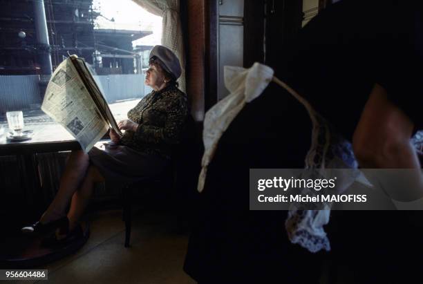 Femme lisant le journal dans un café en novembre 1979 à Prague en République tchèque.