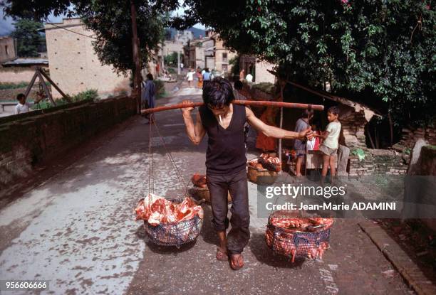 Boucher transportant la viande dans des paniers en 1978 au Népal.