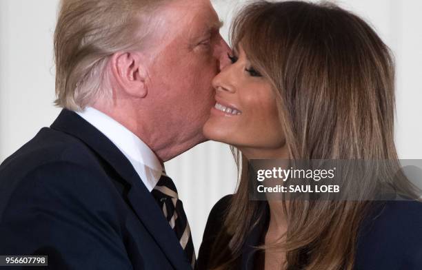President Donald Trump embraces First Lady Melania Trump during an event in honor of Military Mothers and Spouses in the East Room of the White House...